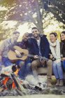 Friends with guitar taking selfie with camera phone at campfire — Stock Photo