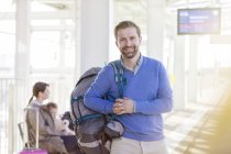Портрет усміхненого чоловіка з рюкзаком в аеропорту — стокове фото