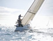 Rear view of sailboat heeling on sunny ocean — Stock Photo