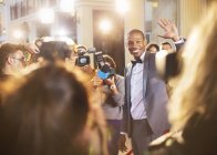 Celebrity waving for paparazzi with cameras at event — Stock Photo