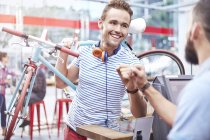 Man with bicycle fist bumping worker in cafe — Stock Photo
