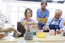 Mature students painting pottery in studio — Stock Photo