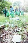Des bénévoles écologistes ramassent des ordures sur le terrain — Photo de stock