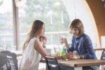 Geschäftsfrauen nutzen Handy in Cafeteria — Stockfoto