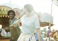 Jovem casal multirracial se divertindo no parque de diversões — Fotografia de Stock
