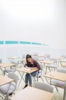 Estudiante sentada sola en el aula durante el examen GCSE - foto de stock