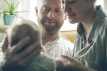 Blick der Eltern lächelnd und mit kleinem Baby — Stockfoto