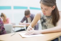 Students writing their GCSE exam in classroom — Stock Photo