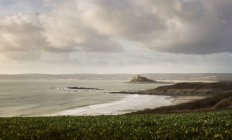 Живописный вид на море с пляжем и холмами в облачный день — стоковое фото