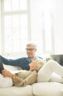 Older couple relaxing together on living room sofa — Stock Photo