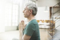 Older man meditating indoors — Stock Photo