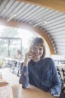 Geschäftsfrau sitzt in Cafeteria am Tisch — Stockfoto