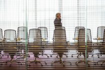 Empresário de pé e usando telefone celular na sala de conferências — Fotografia de Stock