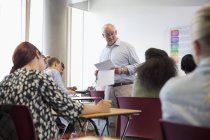 Professor giving exam results to university students — Stock Photo