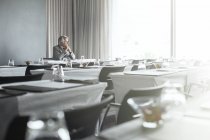 Homem de negócios maduro sentado no restaurante do escritório com as mãos apertadas — Fotografia de Stock