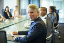 Portrait of  businessman sitting at conference table in conference room — Stock Photo