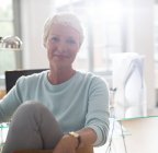 Businesswoman smiling at desk — Stock Photo