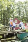 Brothers, father and grandfather walking on dock — Stock Photo