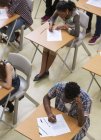 Erhöhter Blick auf Schüler, die ihre gcse-Prüfung im Klassenzimmer schreiben — Stockfoto