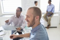 Des gens souriants lors d'une réunion dans un bureau moderne — Photo de stock