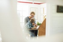 Father and son talking at table in home — Stock Photo