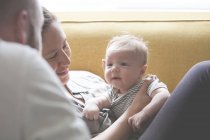 Pais segurando e olhando para o bebê sorrindo — Fotografia de Stock