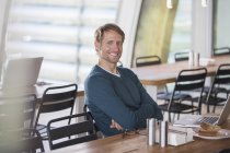 Empresário usando laptop na cafetaria — Fotografia de Stock