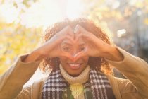 Portrait smiling young woman forming heart-shape with hands — Stock Photo