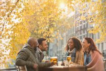 Friends drinking beer at outdoor autumn cafe — Stock Photo