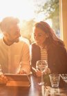 Junges Paar trinkt Weißwein und nutzt digitales Tablet im Café — Stockfoto