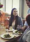 Офіціант, який подає салати жінкам, які обідають за столом ресторану — стокове фото