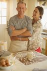 Sorridente coppia affettuosa abbracci, cottura in cucina — Foto stock