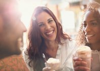 Retrato entusiasta jovem mulher beber milkshake com amigos — Fotografia de Stock