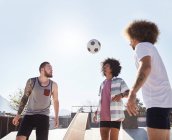 Masculino amigos jogar futebol no ensolarado skate parque — Fotografia de Stock