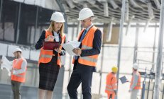 Engineers with clipboards meeting at construction site — Stock Photo