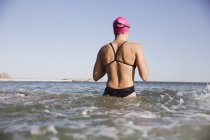 Female active swimmer standing at ocean water outdoors — Stock Photo