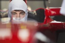 Close up portrait serious formula one race car driver wearing protective mask — Stock Photo