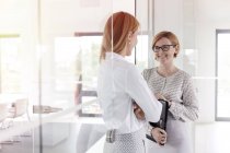 Young businesswomen talking in modern office — Stock Photo
