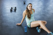 Portrait souriant, confiant jeune femme au repos après l'entraînement dans la salle de gym — Photo de stock