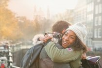 Affectionate young couple hugging on urban autumn street — Stock Photo
