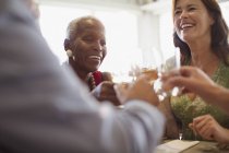 Smiling mature women drinking wine, dining at restaurant — Stock Photo