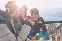 Усміхнені друзі на лижах п'ють коктейлі — стокове фото