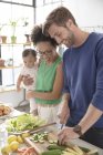 Glückliche Familie bereitet Mahlzeit in der heimischen Küche zu — Stockfoto