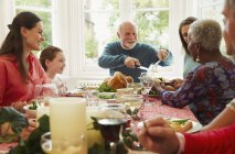 Família multi-étnica desfrutando mesa de jantar de Natal — Fotografia de Stock