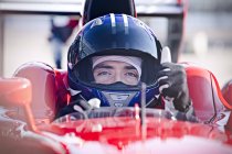 Портрет уверенный в себе мужчина Формула 1 гонщик автомобиля жестом вверх — стоковое фото
