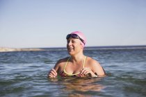 Женщина-пловец, стоящая у океанской воды на открытом воздухе — стоковое фото