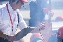 Manager con clipboard e cronometro formula uno pit crew sessione di prove — Foto stock
