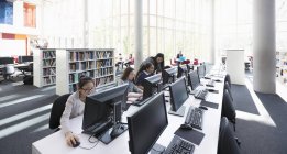 Estudiantes trabajando en computadoras en laboratorio - foto de stock