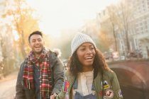 Laughing young couple walking on urban autumn street, Amsterdam — Stock Photo
