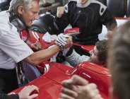 Manager and formula one race car driver handshaking, celebrating victory — Stock Photo